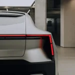 Zadná časť elektromobilu Polestar 4 s červeným LED svetelným pásom v modernom interiéri.