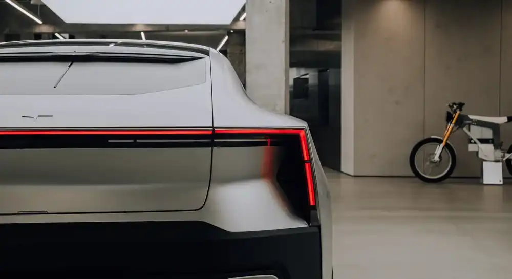 Zadná časť elektromobilu Polestar 4 s červeným LED svetelným pásom v modernom interiéri.